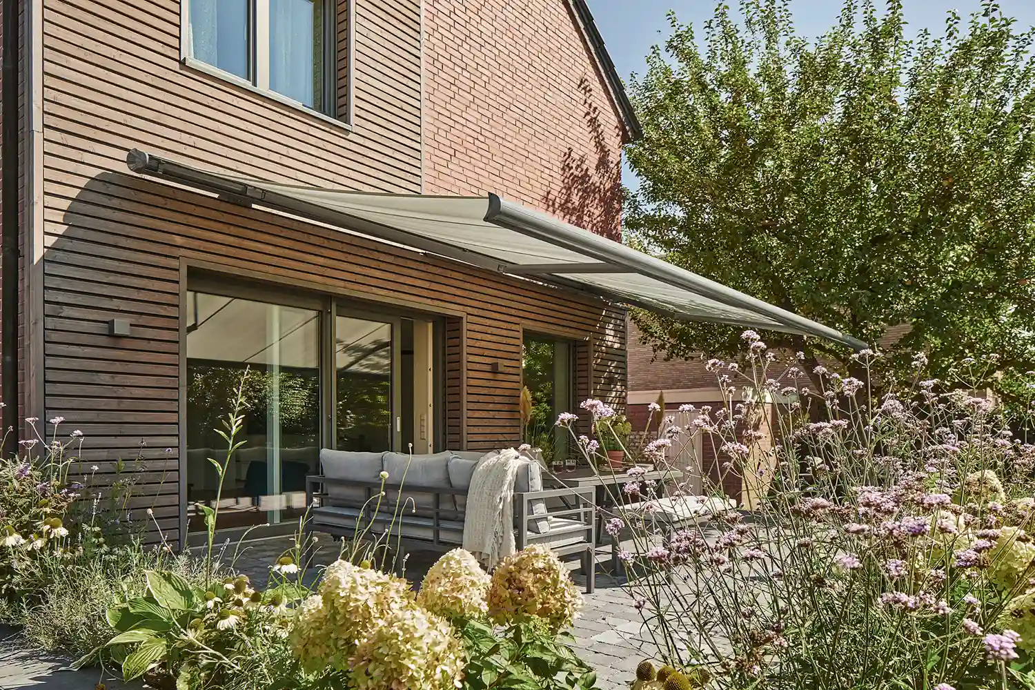 Terrassemarkise eines modernen Hauses Moderne Terrasse mit Gartenmöbeln und Markise