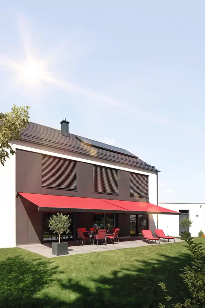 Moderne Terrasse mit rotem Sonnenschutz und Gartenmöbeln