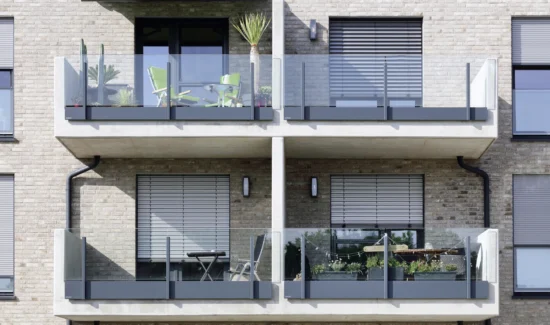 Moderne Balkone mit Glasgeländern an einem Wohngebäude