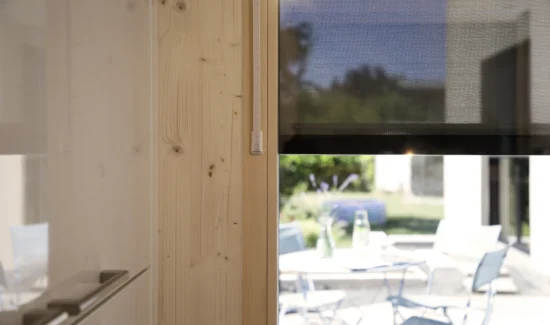 Innenraum mit Holzverkleidung und Blick auf einen sonnigen Außenbereich